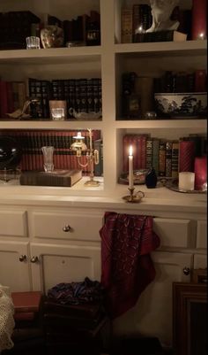 a book shelf filled with books and candles