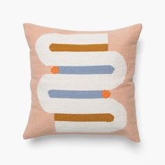 a pink pillow with an orange and blue design on the front, sitting on a white surface