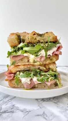 two sandwiches stacked on top of each other with meat and veggies in the middle