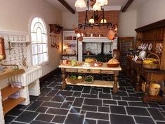 an old fashioned kitchen with black tile flooring and white walls, along with large windows