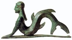 a bronze statue of a mermaid sitting on its back with it's tail curled up