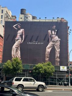 a giant advertisement on the side of a building in new york city, ny with two women wearing pants