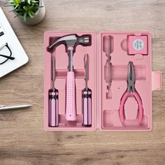 a pink tool box filled with tools on top of a wooden table