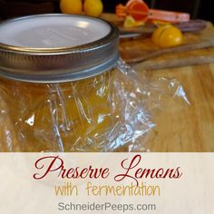 a jar filled with lemons sitting on top of a wooden table