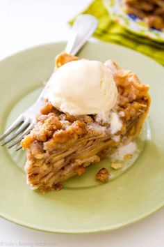 a piece of pie on a green plate with ice cream and a fork in it