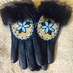 pair of black leather gloves with blue and yellow flower appliqued on them