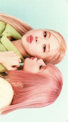 two beautiful young women with pink hair laying next to each other