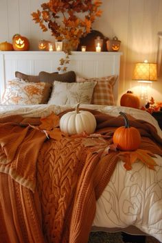 a bed with pumpkins and blankets on it