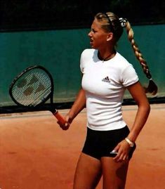 a woman holding a tennis racquet on top of a tennis court