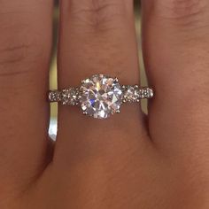 a woman's hand with a ring on it and a diamond in the middle