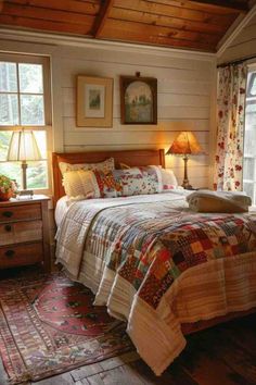 a bed sitting in a bedroom next to two lamps on either side of a window