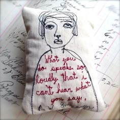 a pillow with a drawing of a woman's face and words written on it