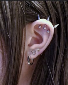 an ear with three piercings attached to it's sides and two smaller ones on the other side