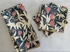 three napkins with floral designs on them sitting on a counter top next to each other