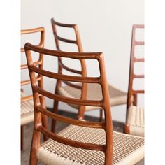 four wooden chairs with woven seats on them