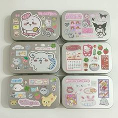 four tins with various stickers on them