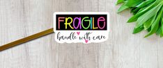 a sticker with the words fragile and hearts on it next to some green leaves