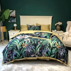 a bedroom with green walls, white furniture and a bed covered in a blue floral comforter