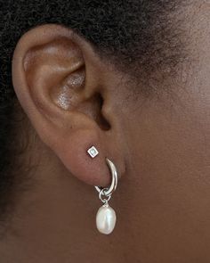 Classy and chic, we’re obsessed with the Willa Gold Pearl Huggie Earrings in White Pearl—and you will be, too! A dainty cultured freshwater pearl dangles from a petite huggie for a lightweight style you’ll pair back with any stack. Metal 14k Gold Over Brass Material White Pearl Closure Ear Post Size 1.8" Outside Diameter, 0.4"L X 0.3"W CharmDue to the one-of-a-kind nature of the medium, exact colors and patterns may vary slightly from the image shown. | Kendra Scott Willa Gold Huggie Earrings in White | Pearl Dainty Dangle Earrings Silver, Small Dangly Silver Earrings, Silver Earrings Classy, Classy Stud Earrings, Double Piercing Earrings Studs, Pearl Earrings Dangle Silver, Simple Wedding Earrings Silver, Earring Combos Double, Beachy Jewelry Silver