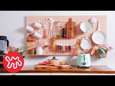 kitchen utensils and plates on a pegboard mounted to the wall above a counter