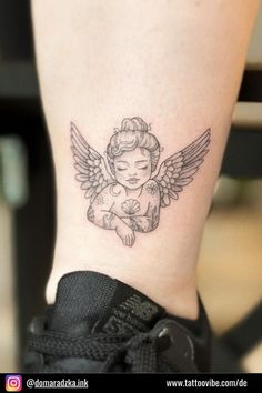 a small tattoo on the ankle of a woman's leg with an angel design