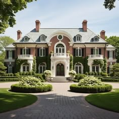 a large brick house surrounded by hedges and trees