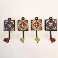 three wall hooks with colorful designs on them