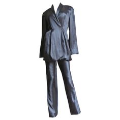 A beautiful black silk pant suit from Yumi Eto. The double breasted shawl collar jacket is gorgeous with matching fine inner adjustable straps which can be moved to different configuration with buttons inside of the jacket to change the hemline shape and length. The pants have straight legs and a back zipper. The jacket has grey mother of pearl buttons in front, all inside seams are beautifully bound finished and both pieces are unlined. Fits sizes Small, Medium. Marked US size 8. Jacket Bust 34 Chic Silk Suits With Notch Lapel, Chic Silk Suit With Notch Lapel, Chic Silk Notch Lapel Suits, Chic Silk Suits For Formal Occasions, Luxury Evening Pantsuit With Notch Lapel, Satin Suits With Long Sleeves For Evening, Long Sleeve Satin Suits For Evening, Satin Long Sleeve Suits For Evening, Evening Satin Suits With Long Sleeves