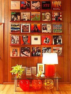 a room with wooden paneled walls and pictures on the wall, including vases