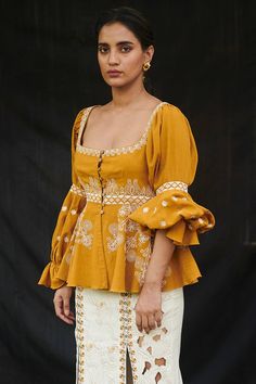 Mustard yellow peplum top with all-over cord work detail and balloon sleeves.
Components: 1
Embroidered
Neckline: Square
Sleeve Length: Full
Fabric: Kala Cotton
Color: Yellow
Balloon sleeves
Tassel tie-up back
Closure: Front buttons
Note: Skirt worn by the model is not for sale - Aza Fashions Cotton Peplum Top, Fancy Dress Ideas, Bakra Eid, Pakistani Party Wear Dresses, Indian Kurti Designs, Designer Kurti Patterns, Casual Indian Fashion, Fancy Tops, Traditional Indian Outfits