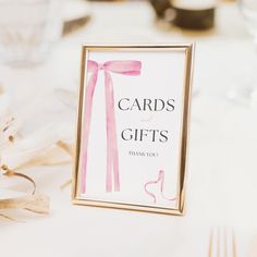 there is a card on the table that says cards and gifts with pink ribbon tied around it