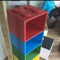 a multicolored bookcase sitting on top of a wooden floor