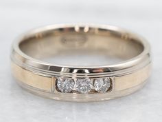 three stone wedding ring set in 18k white gold with diamond center and beveled edge