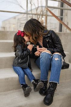 a mother and daughter sitting on the steps