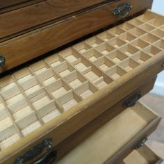 an open drawer is shown with drawers and pulls on the bottom part of the chest