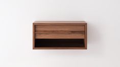 an empty wooden shelf on a white wall