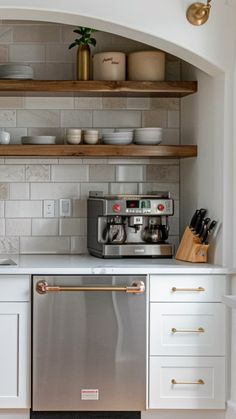 a kitchen with white cabinets and open shelving above the dishwasher is shown