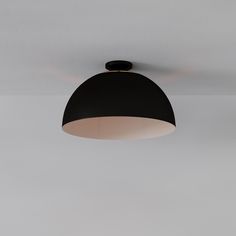 a black and white light fixture hanging from the ceiling in a room with gray walls