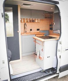 an open van door showing the kitchen and dining area