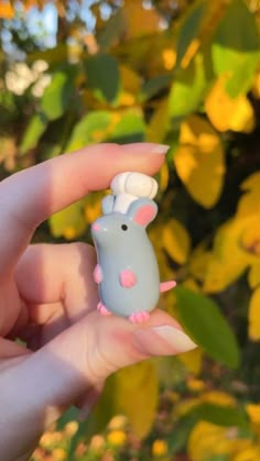 a person holding a tiny toy mouse in their hand