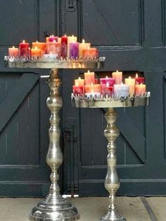 two metal trays filled with candles sitting on top of each other