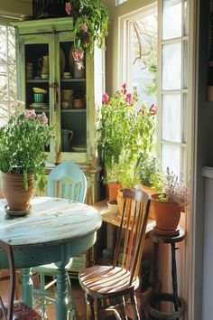 a table and chairs with potted plants in the window sill next to each other