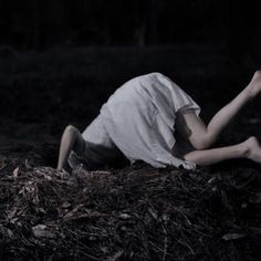 a young man laying on the ground with his legs spread out