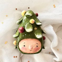 a ceramic christmas tree ornament on white fabric