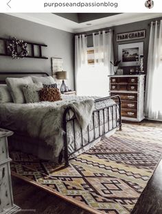 a bedroom with a bed, dressers and rug in it's center area