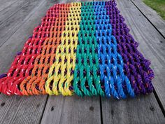 a multicolored knitted rug sitting on top of a wooden table next to grass