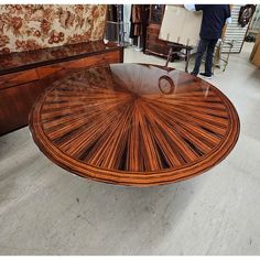 a wooden table with glass top on display in a room filled with furniture and other items