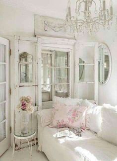 a white couch sitting in a living room under a chandelier