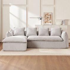 a living room with white walls and wooden floors, an l shaped couch is on the floor