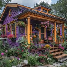 a purple and yellow house with flowers on the porch